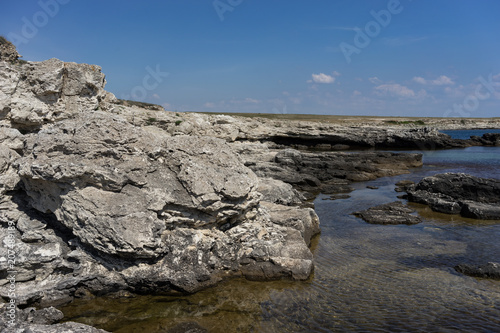 Rocks and stones on the background of the sea under the blue sky.