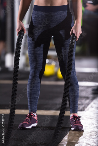 athlete woman doing battle ropes cross fitness exercise