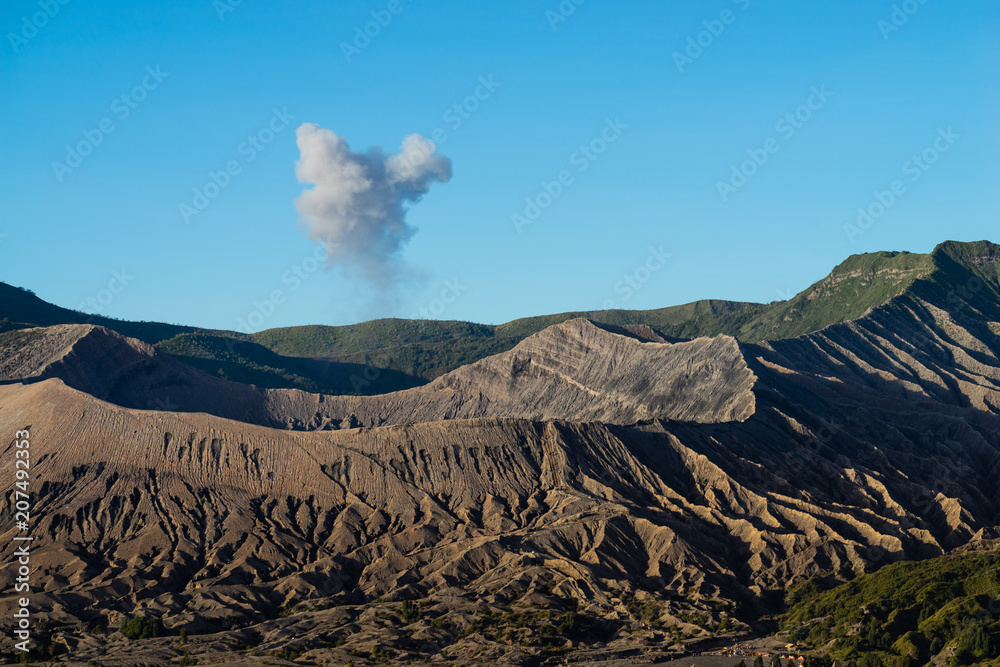 Beautiful view landscape of active volcano crater with smoke at Mt. Bromo, East Java, Indonesia.