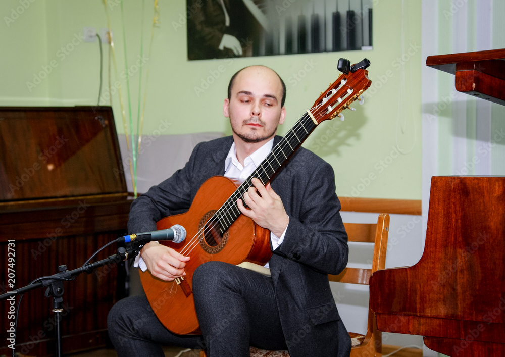 Obraz premium The guitarist performs a piece of music and puts his soul into it.