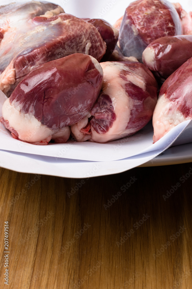 Isolated bird chicken giblets gizzards stomachs, hearts . Raw uncooked chicken turkey gizzards background