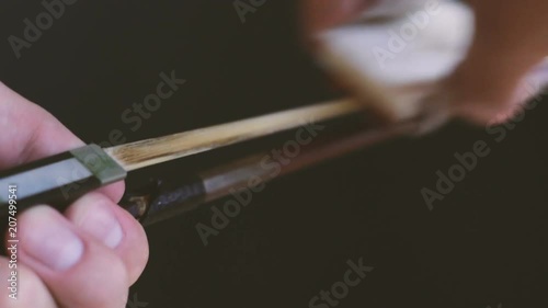 Applying rosin to a violin bow