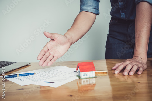 Close up business man reaching out sheet with contract agreement proposing to sign.Insurance agent and insurance company customers.Concept of insurance with house and car