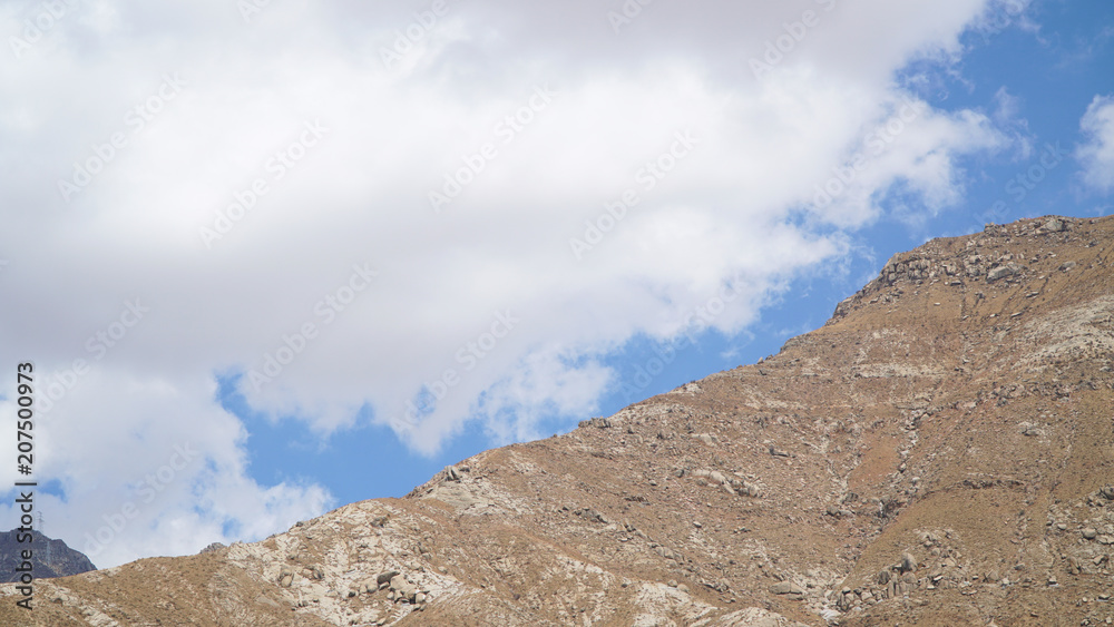 Mountain peak with some clouds and clear blue sky