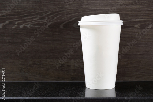 Disposable hot coffee cup on table in coffee shop