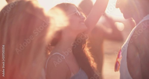 Young multi-ethnic hipsters dancing at summer beach music festival photo