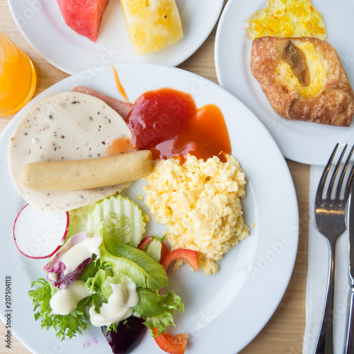 breakfast with fied eggs,ham, bacon, .bread ,orange juice , and salad on the table ,top view