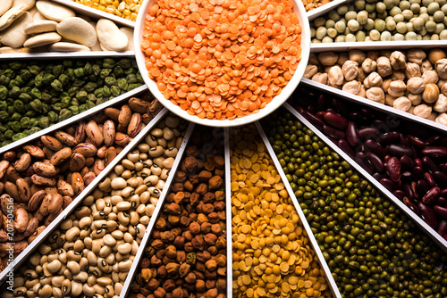 Indian Beans,Pulses,Lentils,Rice and Wheat grain in a white Sunburst or sun rays shape designer container , selective focus.