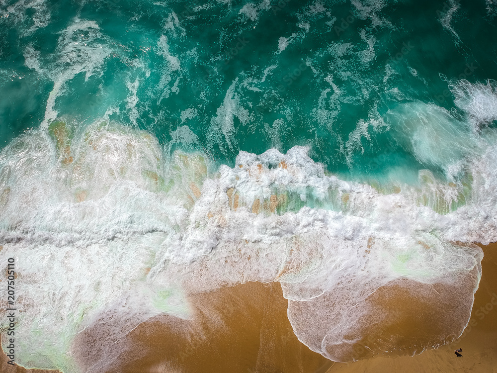 Sand beach aerial, top view of a beautiful sandy beach aerial shot with the blue waves rolling into the shore