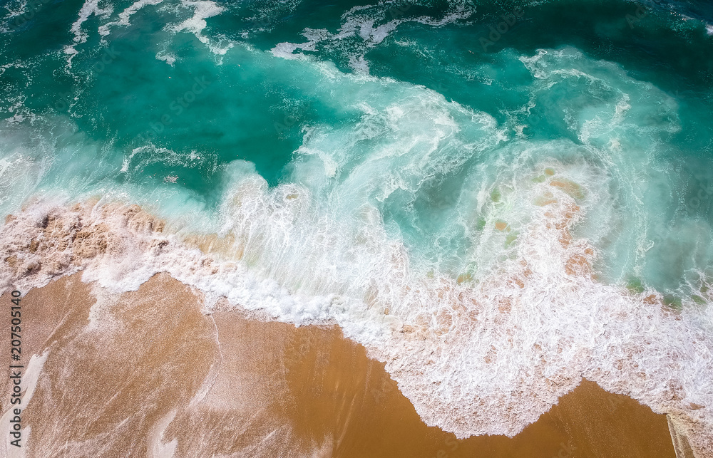 Sand beach aerial, top view of a beautiful sandy beach aerial shot with the blue waves rolling into the shore Sand beach aerial, top view of a beautiful sandy beach aerial shot with the blue waves rolling into the shore