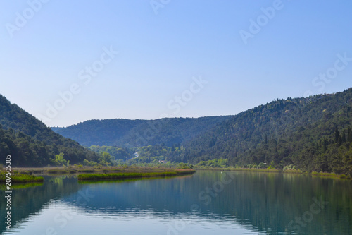 Scenic river valley background with green forests and water