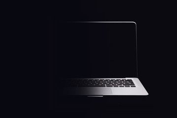 Portable modern silver computer on a black background.