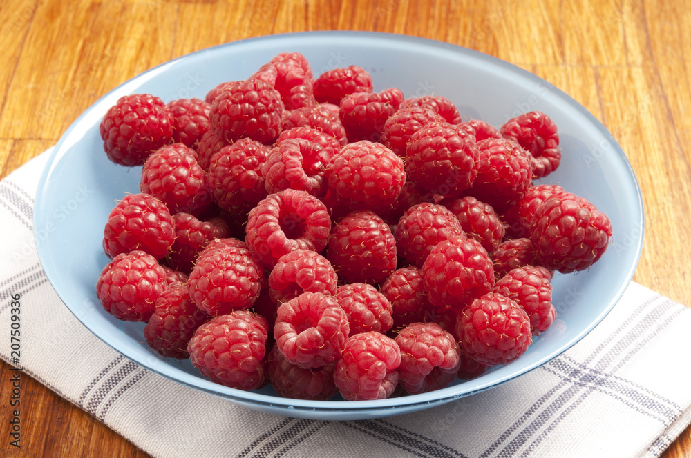 red raspberries in bowl with rustic dishtowel, summer fruit red raspberries in bowl with rustic dishtowel, summer fruit