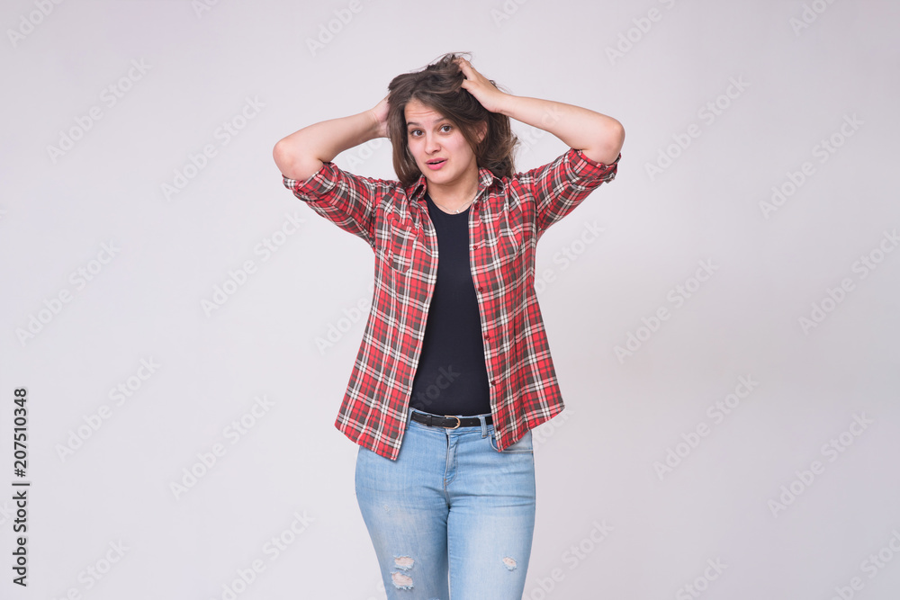 portrait of a beautiful brunette girl on a white background in jeans in different poses with different emotions