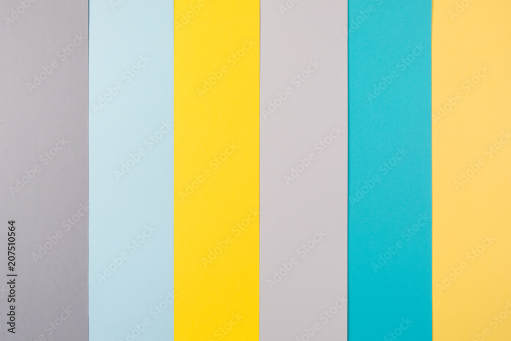 multi-color paper geometric background made of cardboard sheets. yellow, turquoise, gray, blue vertical stripe. flat lay, top view, copy spase