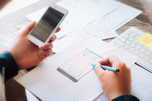 Web designer planning application for mobile phone. Design Online Technology Content, Ideas Proposal Strategy Tactics Vision Design Concept