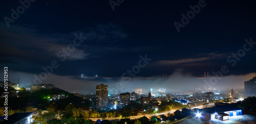 Vladivostok cityscape night view. Fog over the city.