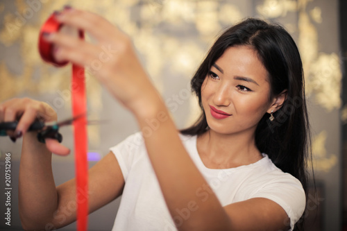 Pretty woman cutting a red ribbon