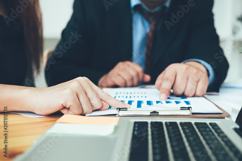 Business man supervising and secretary to execute business plan and consultant analyzing company annual financial report balance sheet statement working with documents graphs. Audit and consultant