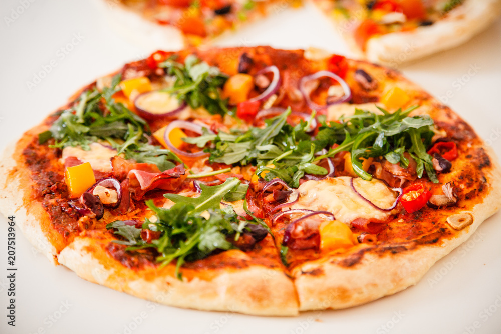 Pizza with ham and vegetables on wooden table