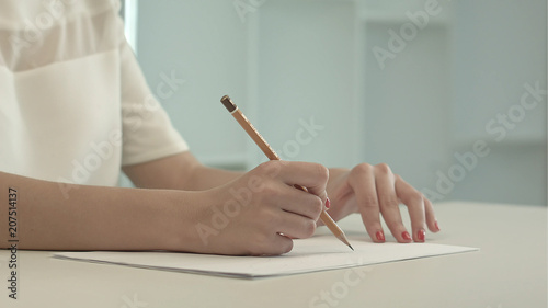 Woman with pencil writing on paper