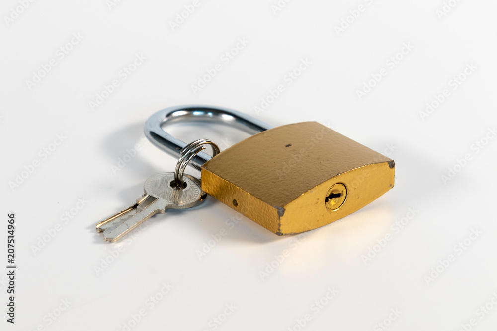 Closed golden padlock with a wad of small silver keys Closed golden padlock with a wad of small silver keys