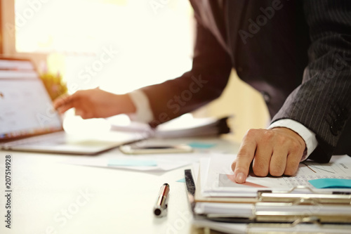 Businessman working with digital computer in modern office with virtual icon diagram at modern office in morning light