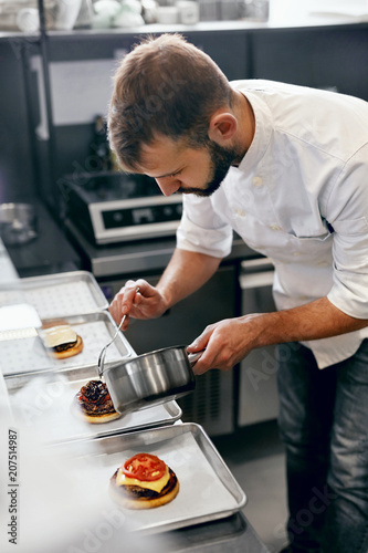 Fototapeta Naklejka Na Ścianę i Meble -  Chef Cooking Burgers in Kitchen