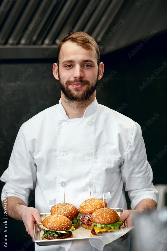 Chef With Burgers In Restaurant Kitchen