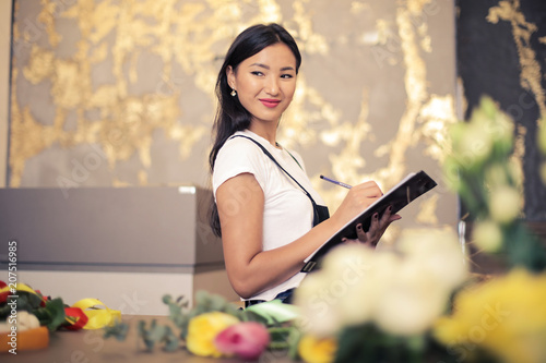 Smiling woman working in a flower shop photo