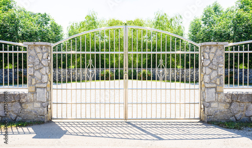 Chrome fence gate. Chromium Stainless steel fence on stone wall