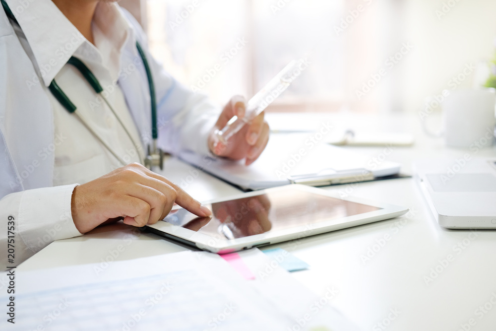 Medical Technology , Close up doctor reading a report in tablet computer on workplace. Medical Technology , Close up doctor reading a report in tablet computer on workplace.