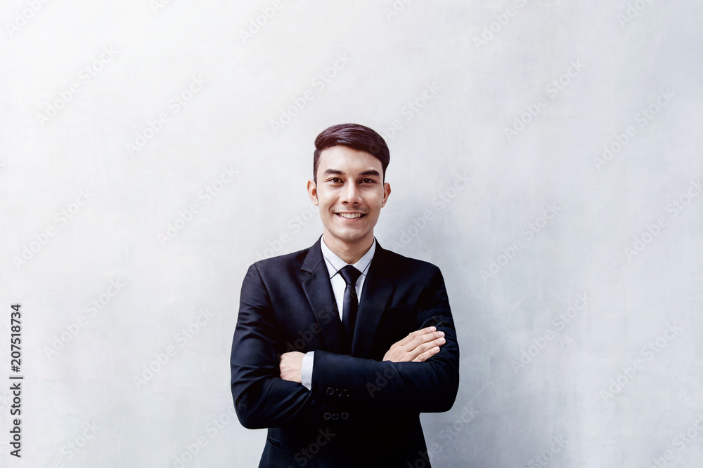 Portrait of Happy Young Businessman standing at the Wall, Smiling and Crossed Arms, Looking at camera Portrait of Happy Young Businessman standing at the Wall, Smiling and Crossed Arms, Looking at camera