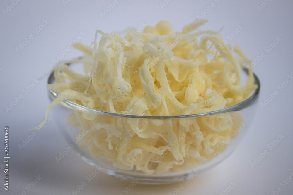 Dried squid shavings in a transparent plate on a white background. Dried squid shavings in a transparent plate on a white background.