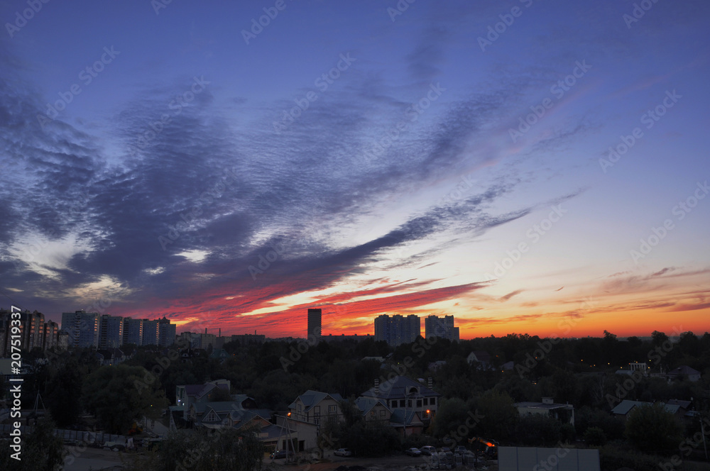 Bright colourful sunset in the urban city in summer. Panorama of the modern town Bright colourful sunset in the urban city in summer. Panorama of the modern town