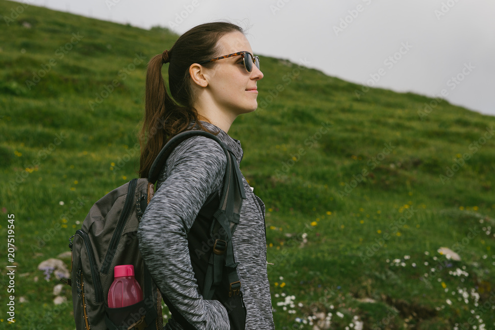 Young Women backpacker in the mountains enjoy the view on a lovely day Young Women backpacker in the mountains enjoy the view on a lovely day