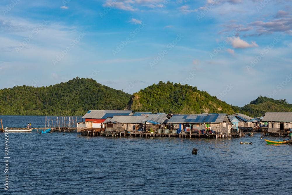 houses on stilts in Yellu village at sunset, east Misool, Indonesia houses on stilts in Yellu village at sunset, east Misool, Indonesia