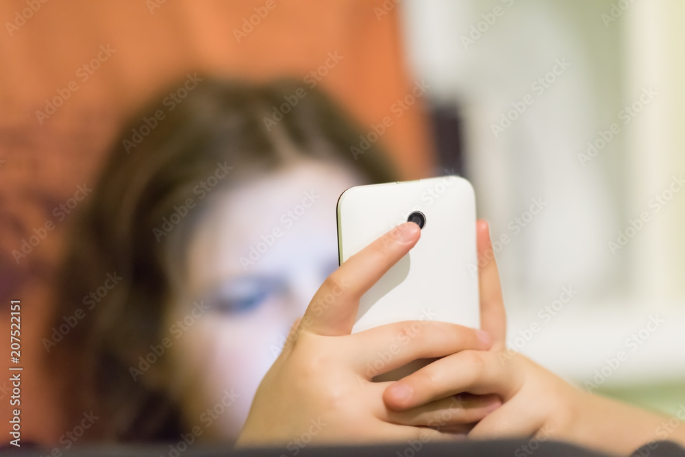 Image of a cute teenager busy messaging on her smartphone
