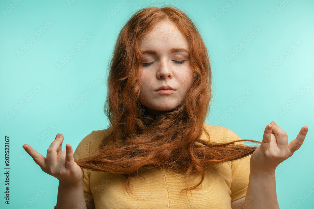 Beautiful calm young redhead female with hair tied crossed around her neck  closed eyes, holding hands in mudra gesture. Hair Care Industry Stock Photo  | Adobe Stock