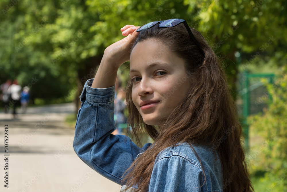 young girl with long hair holds her glasses on her head and smiles young girl with long hair holds her glasses on her head and smiles