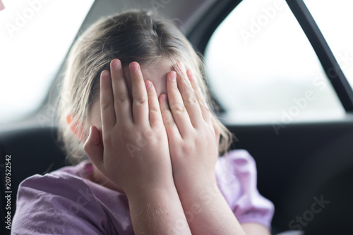 girl in the car covered her face with her hands in surprise