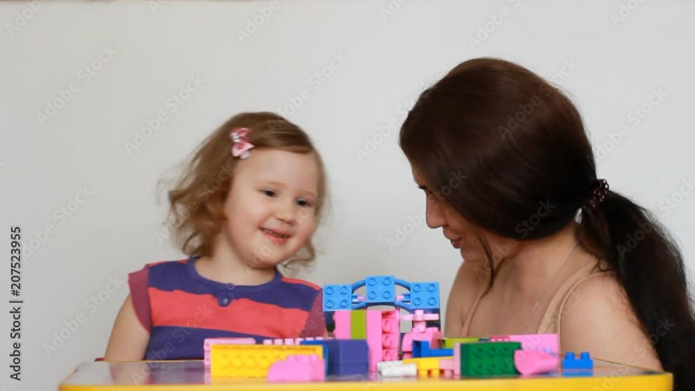 Mother and child playing together in the game building a constructor. Mother and child playing together in the game building a constructor.