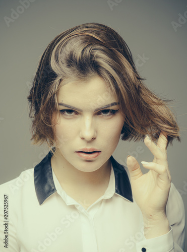 Schilderij op canvas Woman on mysterious face touches her hair, grey background