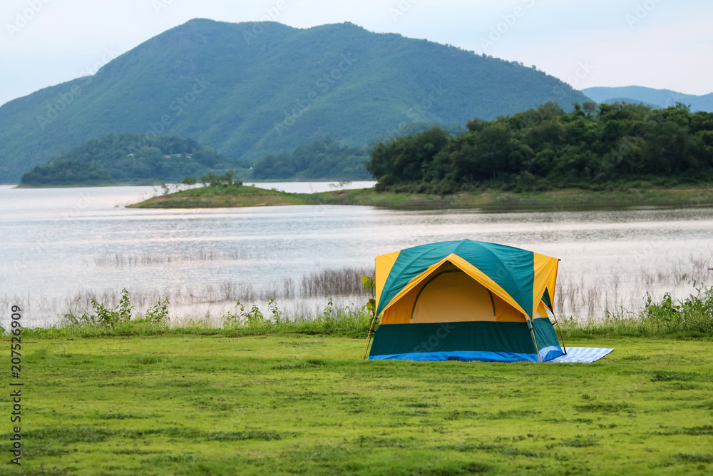Campsite and tents on the lawn with beautiful green nature landscapes of dam water
