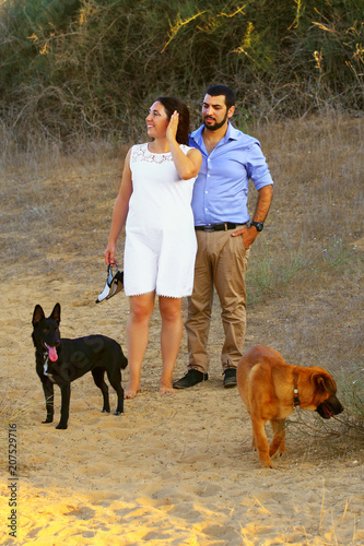 A young couple walk their two dogs