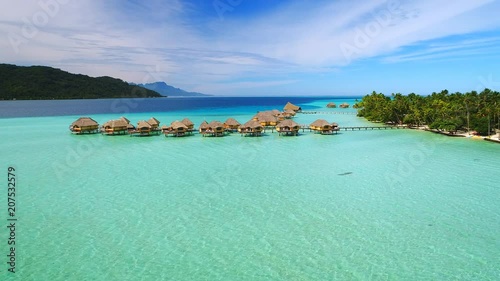 Aerial view of Motu Tautau, palm trees on little islets and turquoise water of blue lagoon, over water bungalows, tropical paradise of South Pacific Ocean - Tahaa island, seascape of French Polynesia photo