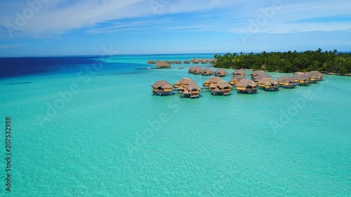 Aerial view of Motu Tautau, palm trees on little islets and turquoise water of blue lagoon, over water bungalows, tropical paradise of South Pacific Ocean - Tahaa island, seascape of French Polynesia photo