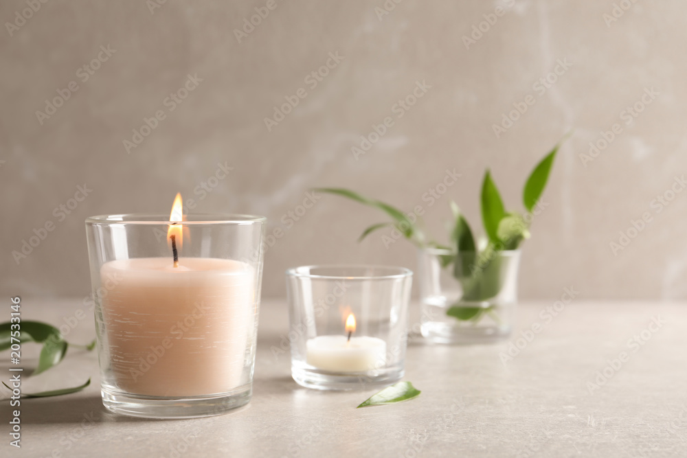 Burning wax candles in glasses on table Burning wax candles in glasses on table