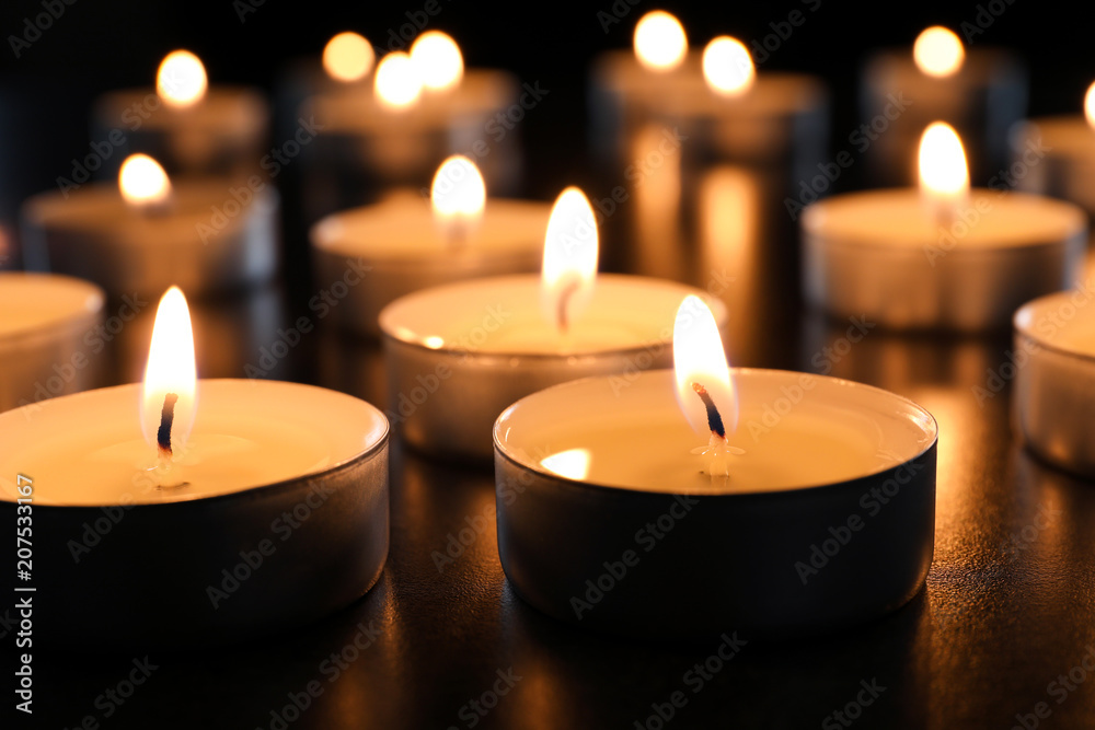 Wax candles burning on table in darkness, closeup Wax candles burning on table in darkness, closeup