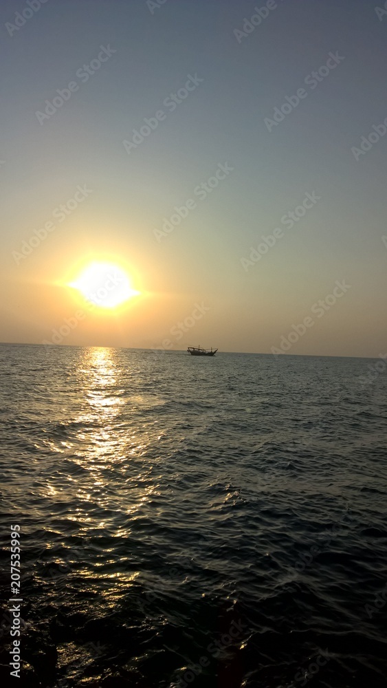 Fototapeta premium sunset on the ocean with boat